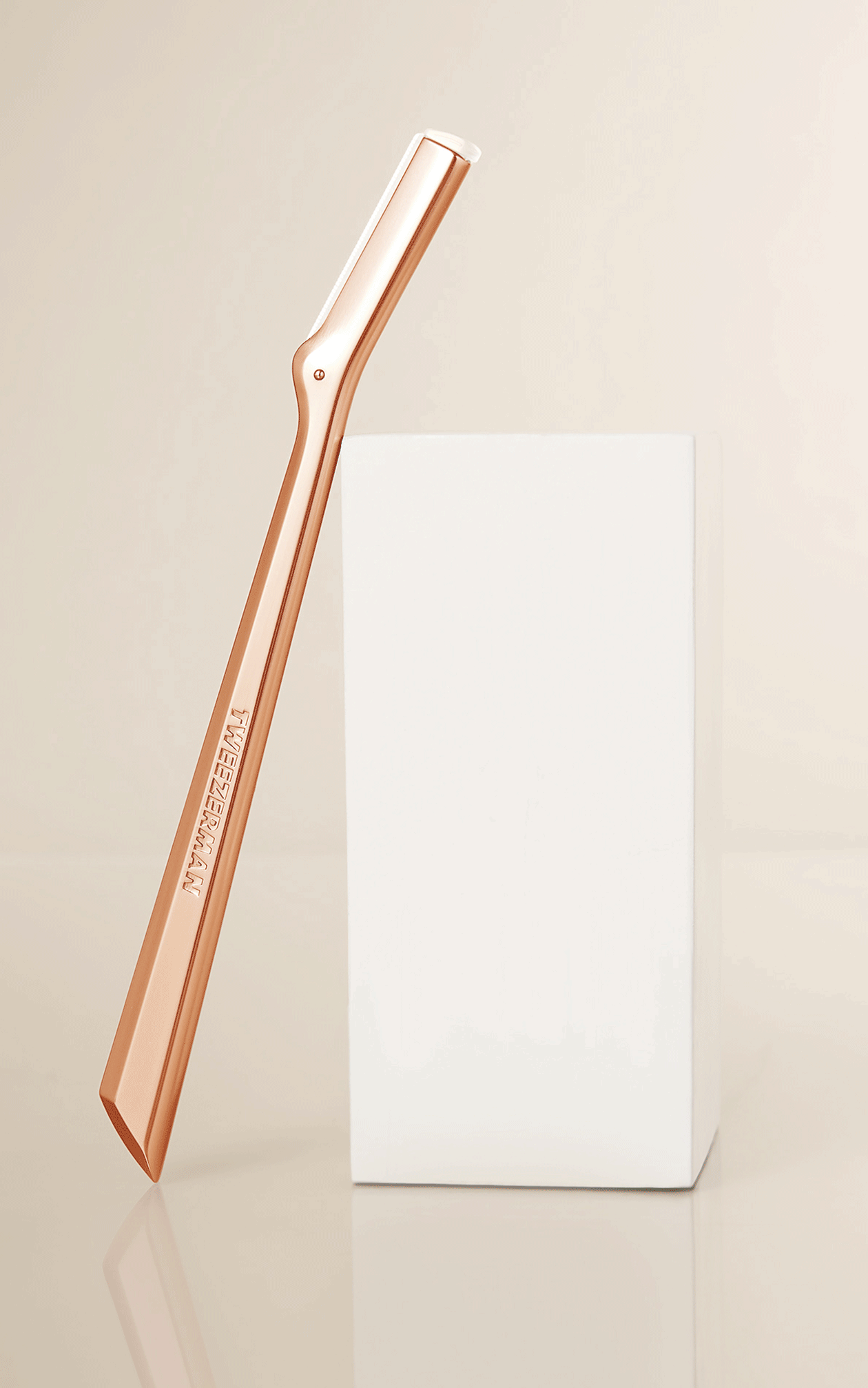 Set of makeup tools including rose gold facial razor, pistachio slant tweezer