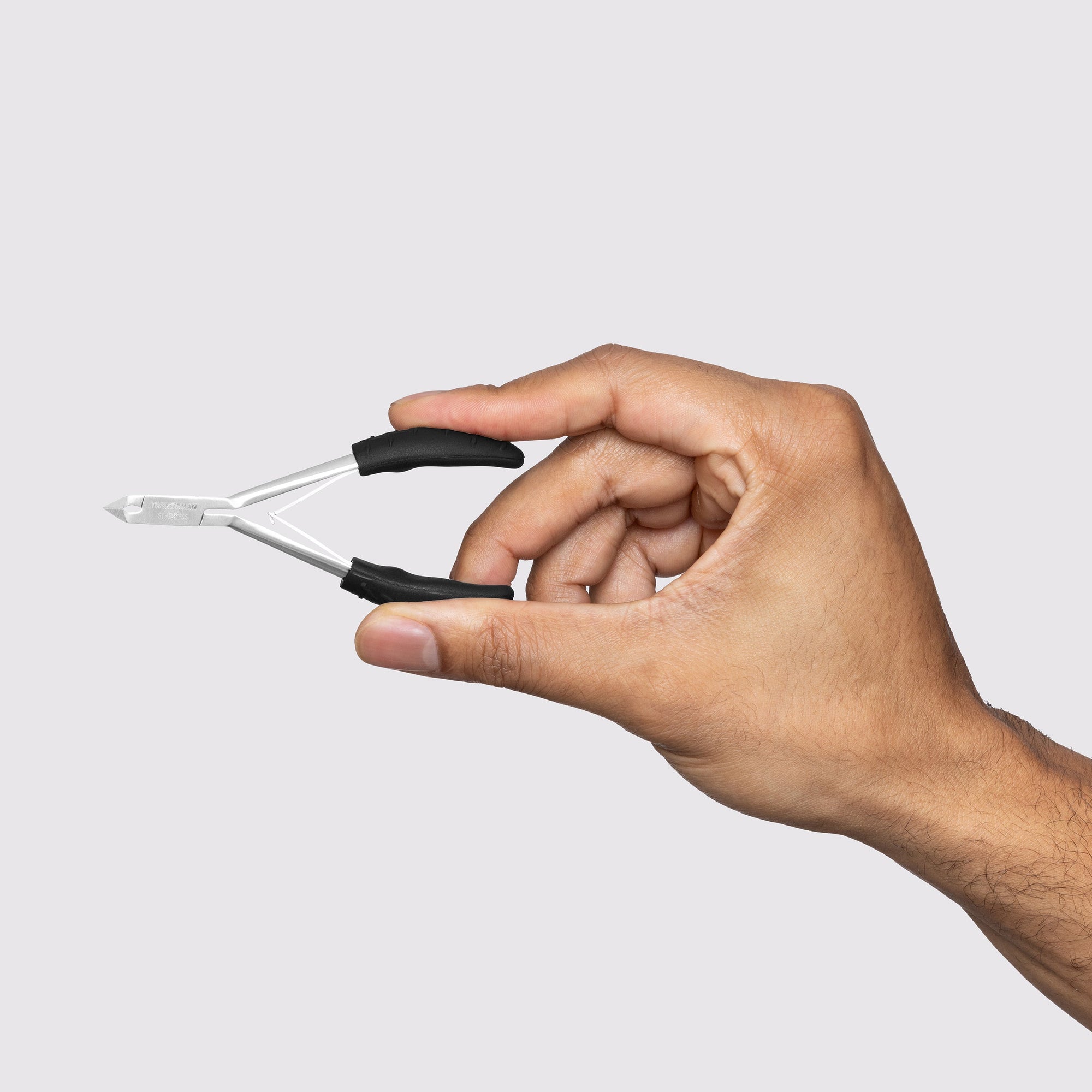 Mains de mannequin masculin utilisant un pincement à cuticules Great Grip pour couper les cuticules des ongles