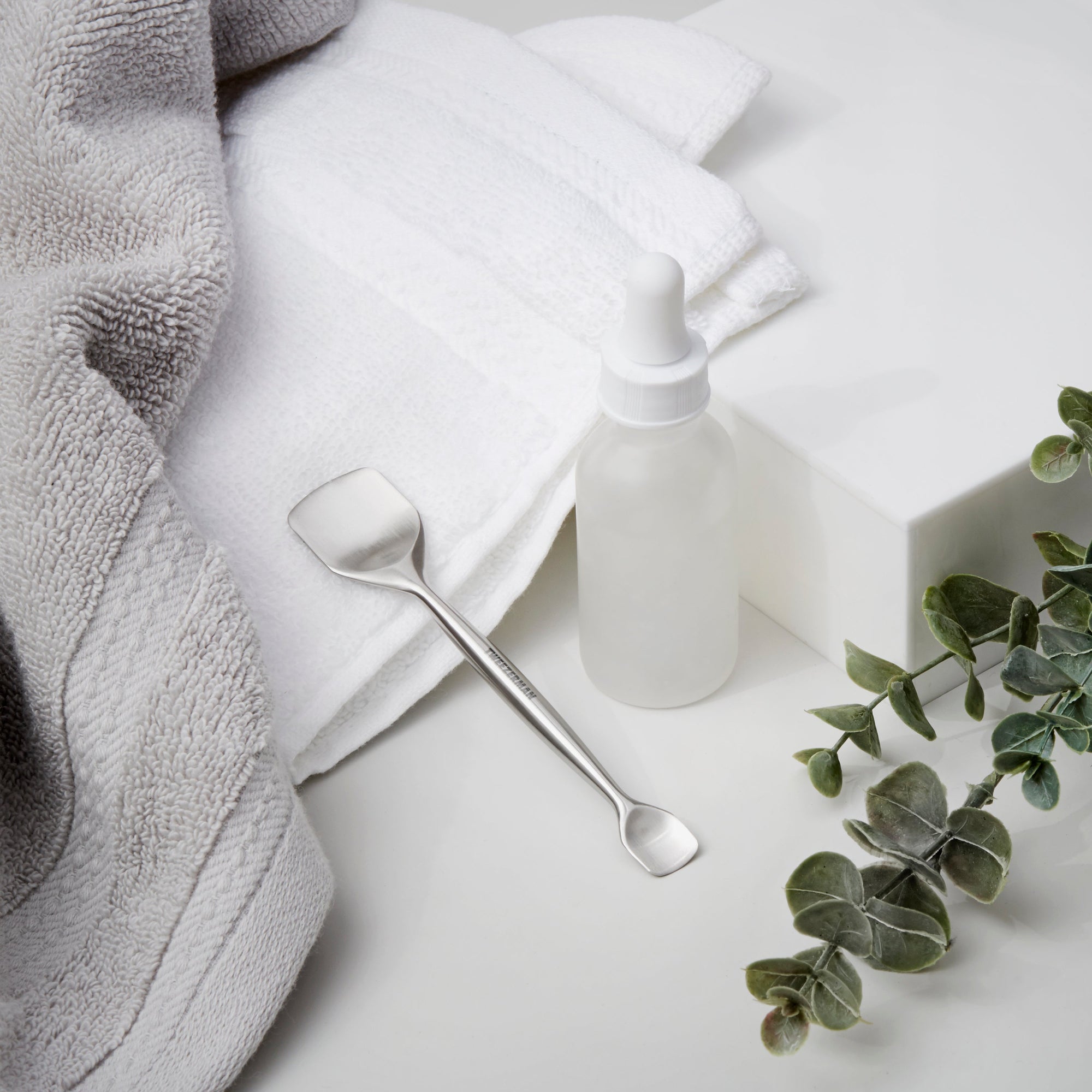 Pore prep tool next to towel and dropper bottle
