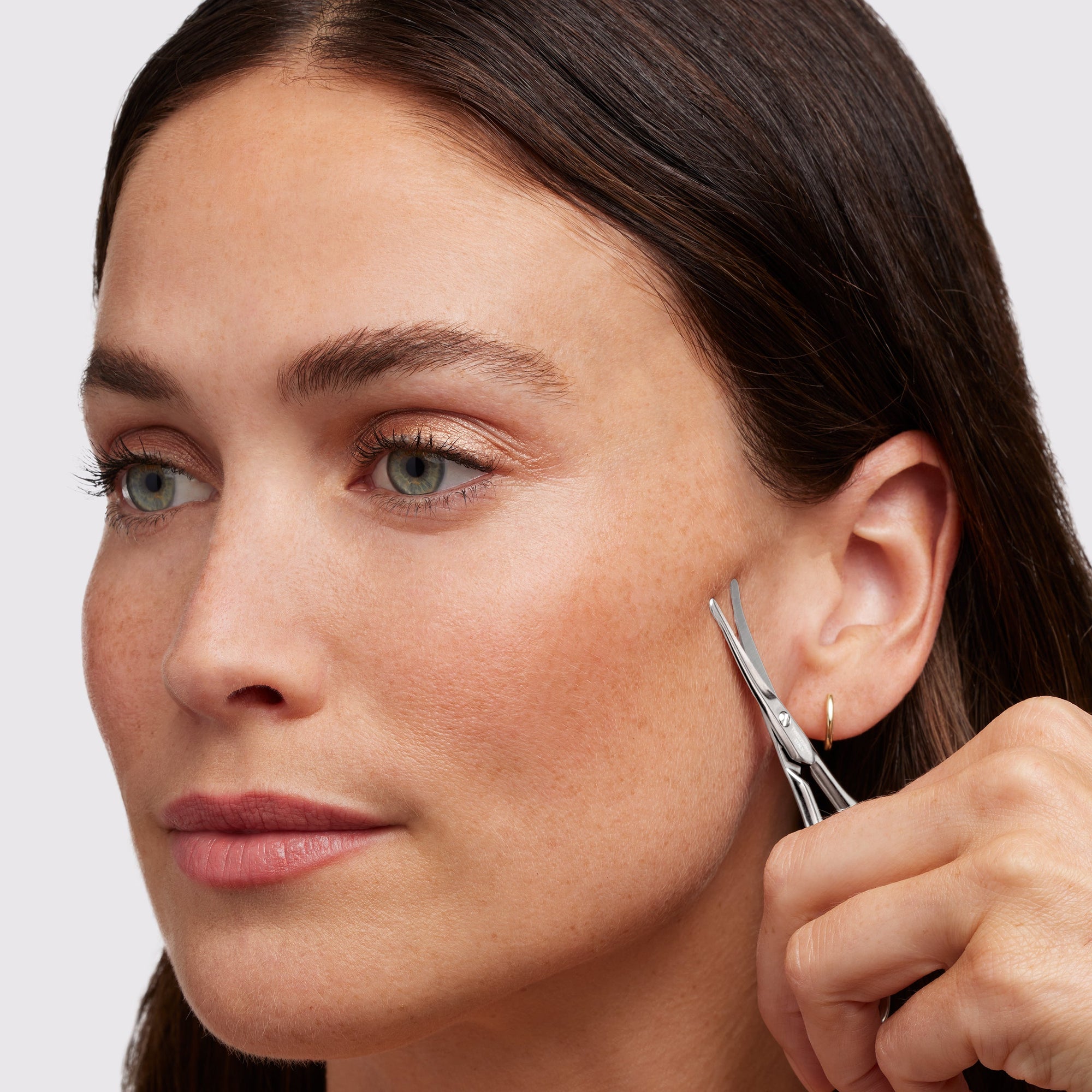 Mannequin féminine utilisant des ciseaux en acier inoxydable pour la pilosité faciale sur le visage