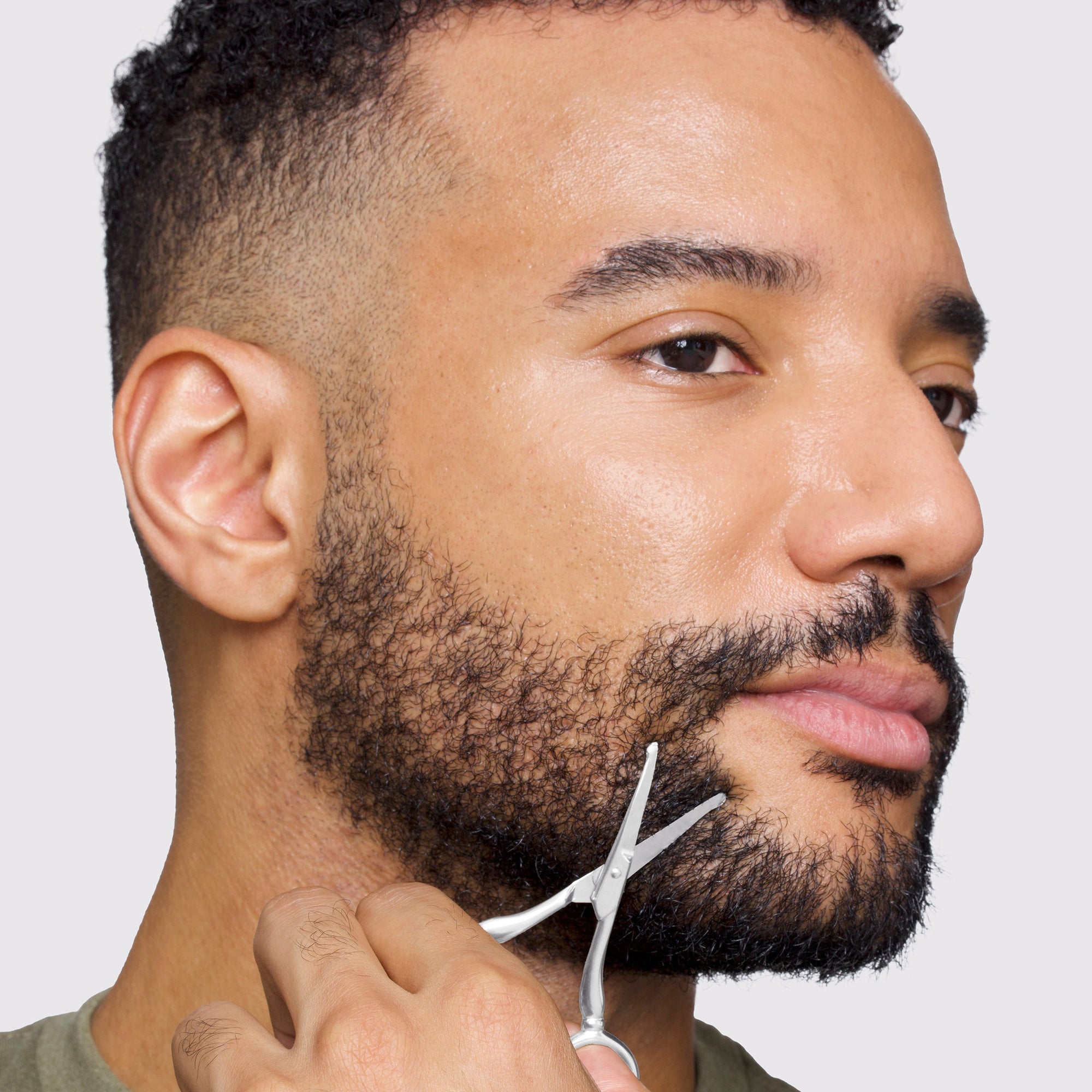 Mannequin masculin utilisant des ciseaux en acier inoxydable pour la pilosité faciale sur du pain